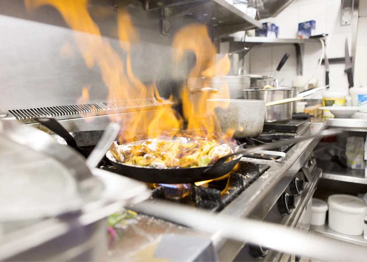 Flambierte Pfanne in der Küche