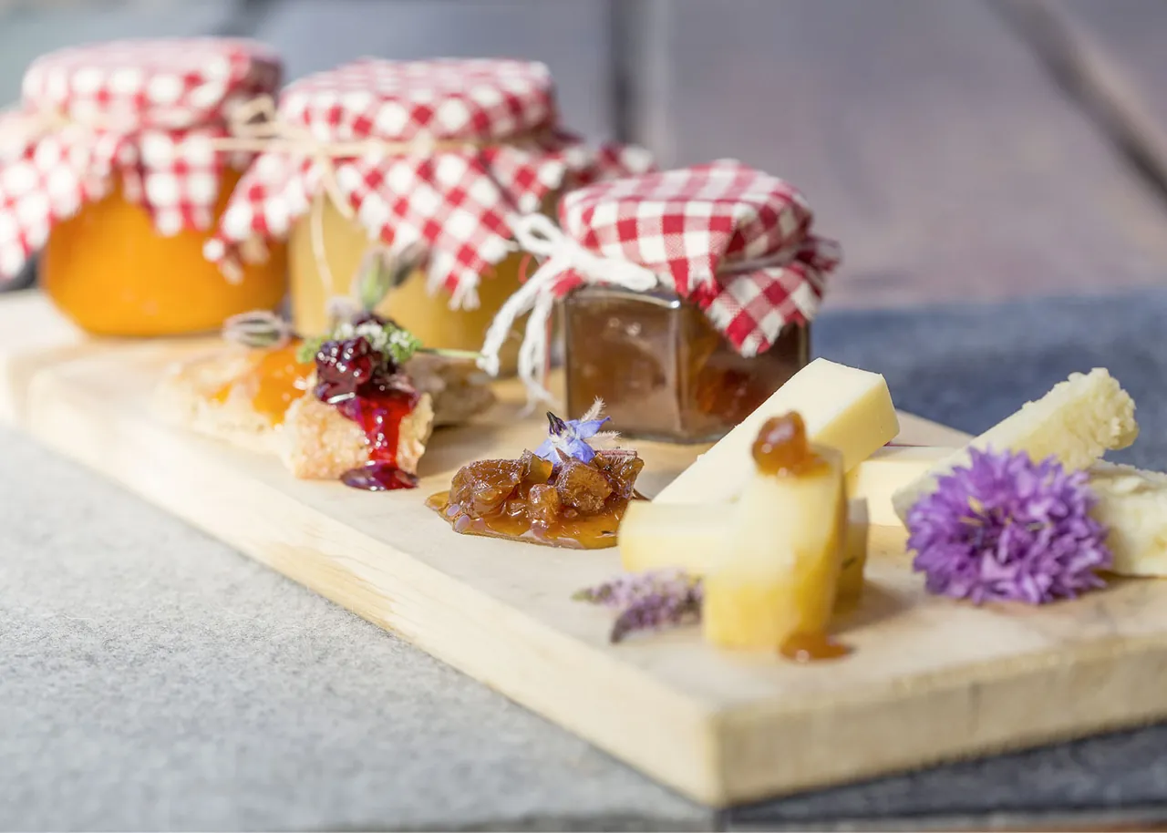 Marmeladen im Karo-Glas und Käse auf dem Brett